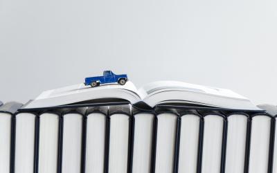 Matchbox car driving over an open book