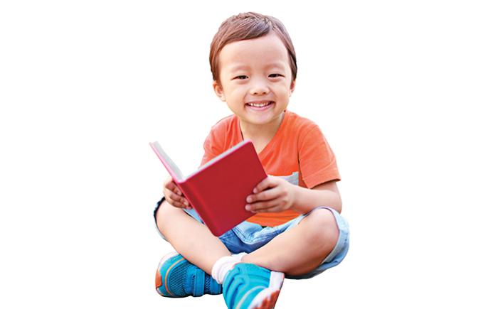 Preschooler sitting with a book in his lap