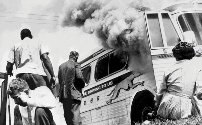 People standing near a disabled Grayhound bus