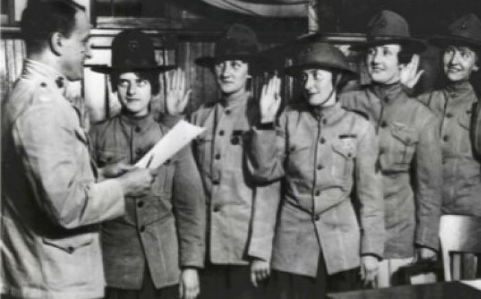 Man swearing in a group of women in military uniform