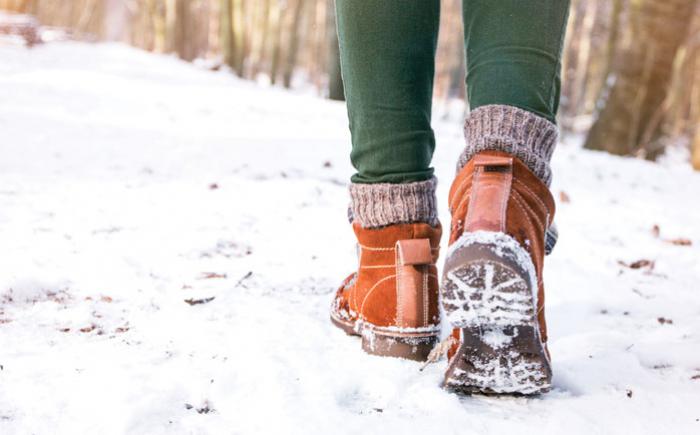 A person in boots walking in the snow