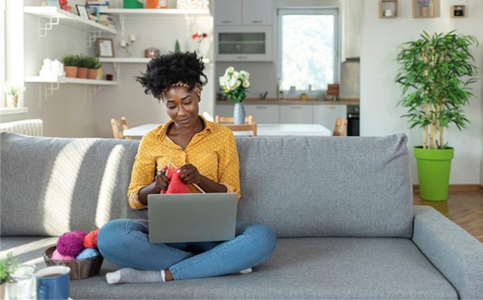 Woman with a laptop knitting