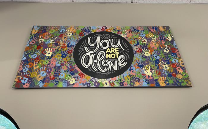 You are Not Alone mural by Andrea Nadolny hangs above the windows on the east wall of Old Worthington Library
