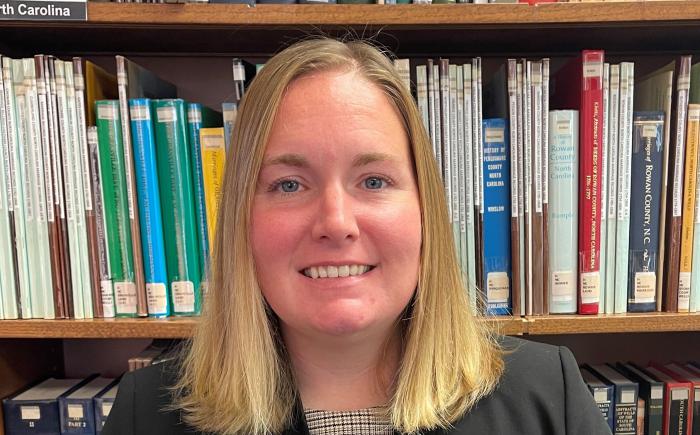 Headshot of Lauren Robinson in front of library bookshelves