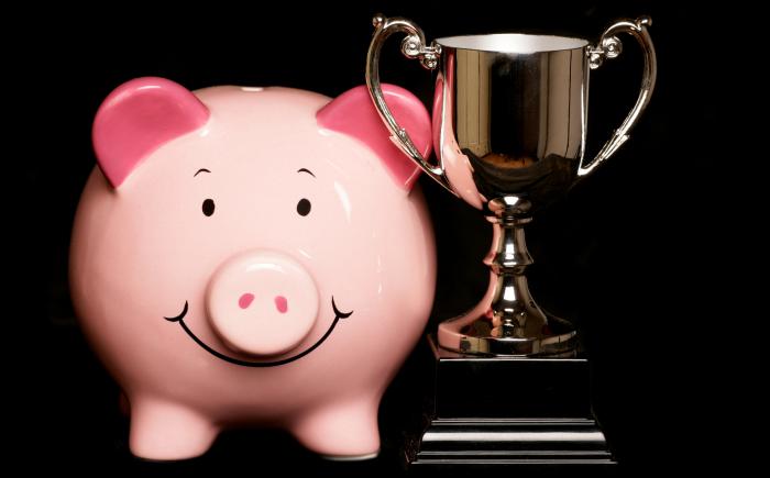 PIggy bank next to a trophy