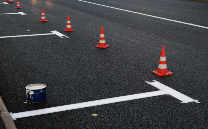 A parking lot with orange traffic cones that is currently undergoing repairs.