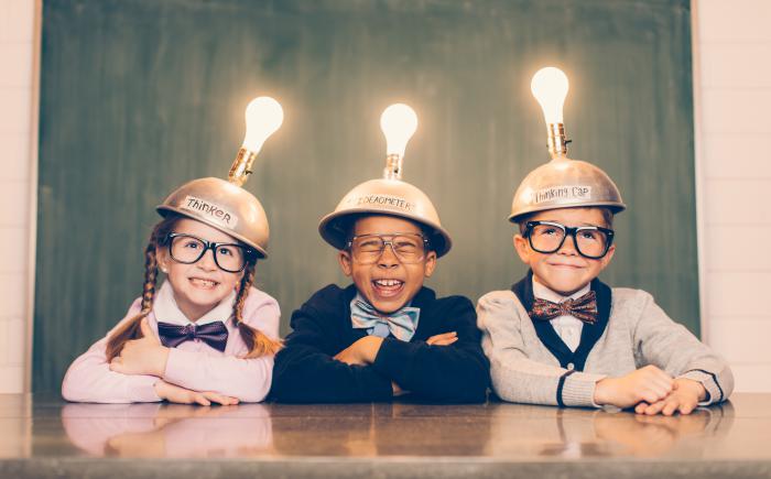 Three kids wearing glasses, bow ties and light bulb caps.