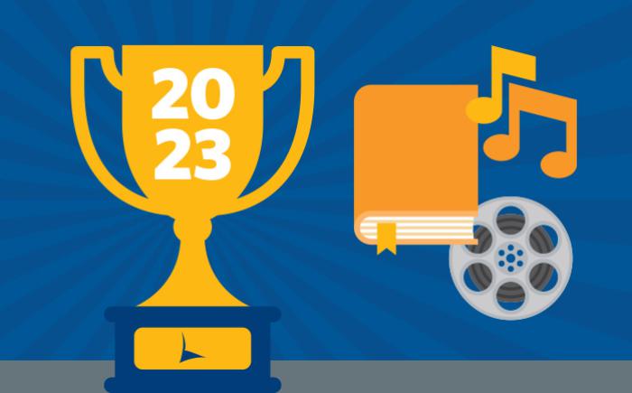 Trophy labeled 2023 next to a book, music notes and film reel