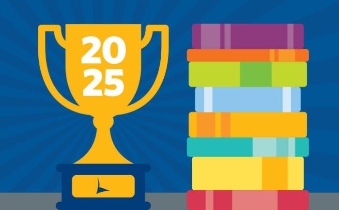 Trophy labeled 2025 next to a stack of books