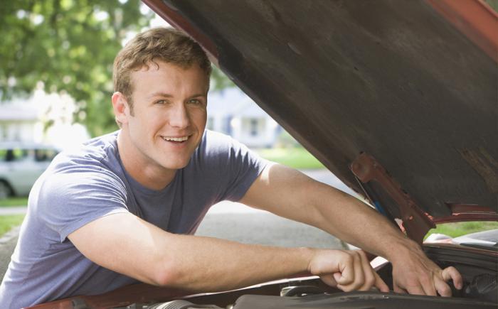 Man working on car with hood raised