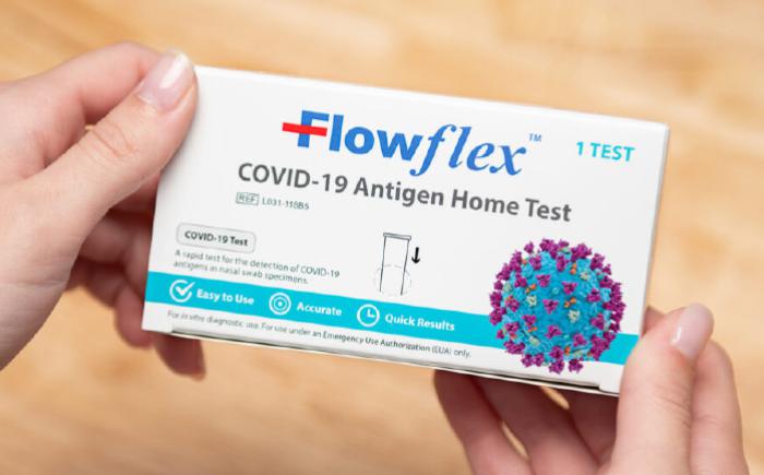 Flowflex COVID-19 test box in woman's hands