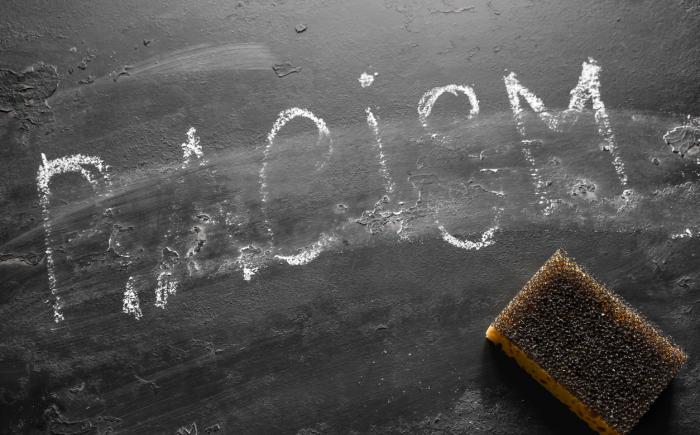 Blackboard on which the word racism has been partially erased