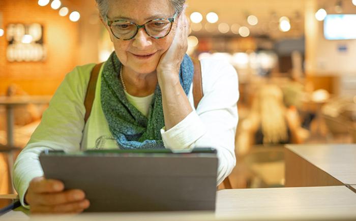 Mature woman looking at a tablet in a restaurant