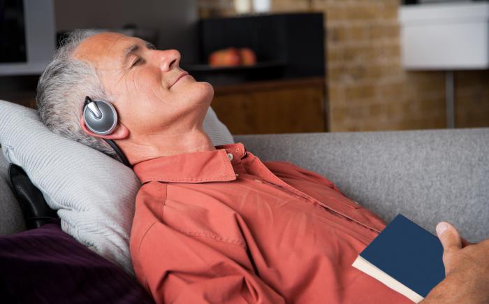 Man relaxing on couch wearing headphones