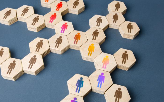 Wooden hexagonal tiles with a person icon on them in different colors