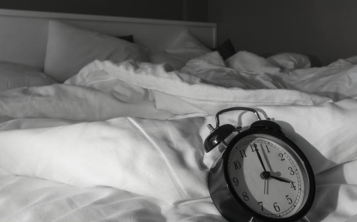 Alarm clock on an unmade bed