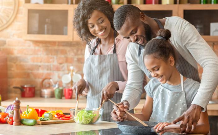 Two adults and a child preparing a meal