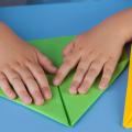 Child's hands folding a paper airplane