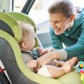 Woman buckling baby into car seat