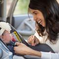 Woman buckling baby into car seat