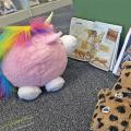Stuffed animals looking at open books