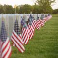 American flags in front of headstones at a cemetery