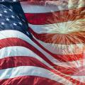 Waving American flag with fireworks