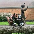 Reading with Friends sculpture portraying a fox, raccoon and owl reading on a log