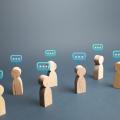 Wooden people figurines with speech bubbles above them
