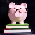 Piggy bank wearing glasses on a stack of books