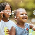 Children blow bubbles outdoors