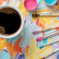 Mug of coffee, paint and paintbrushes