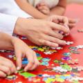 Hands assembling jigsaw puzzle pieces