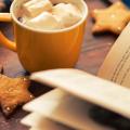 An open book with cookies and a mug