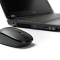 Mouse with scroll wheel in front of laptop