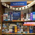 Shelves with puzzle boxes on display and a sign that reads Puzzle Exchange