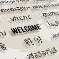"Welcome" in multiple languages against a world map
