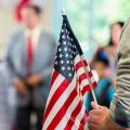 People gathered with someone holding an American flag