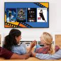 Two couples sit on couch with TV displaying Black Joy Film Series promotion