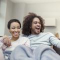 Happy couple watching TV on a couch