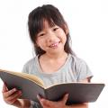 Girl holding a book and smiling