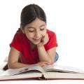 Girl lying down reading a book