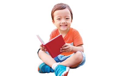 Preschooler sitting with a book in his lap