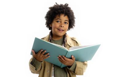 Tween-aged boy holding book in arms