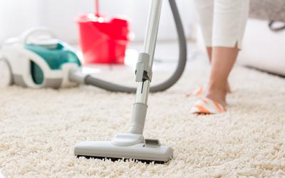 Person vacuuming a carpet