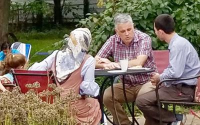 Group of children and adults eating outdoors