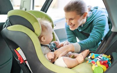 Woman buckling baby into car seat