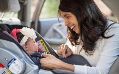 Woman buckling baby into car seat