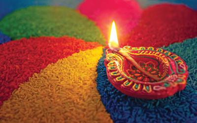 Diya surrounded by brightly colored rice