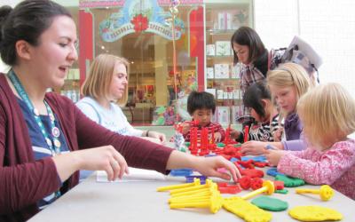 Kids and adults using stamps in Play Doh